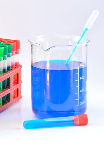 Chemische bekerglas met blauwe chemicaliën in water opgeloste - Foto, afbeelding