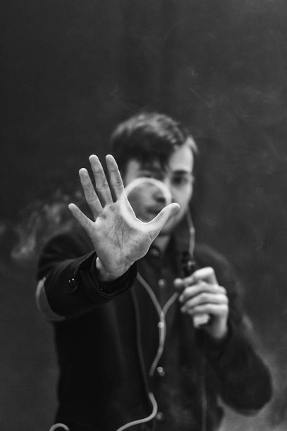 Young handsome white guy let rings out of steam. Vaping. Electronic cigarette. Black and white photo. - Foto, immagini