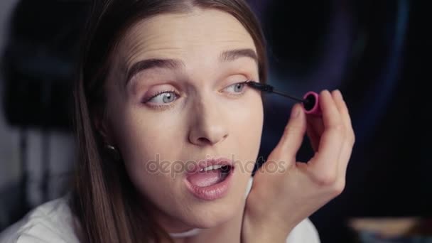 beautiful young girl paint eyelashes mascara in a good mood, opens her mouth HD, 1920x1080. - Materiał filmowy, wideo