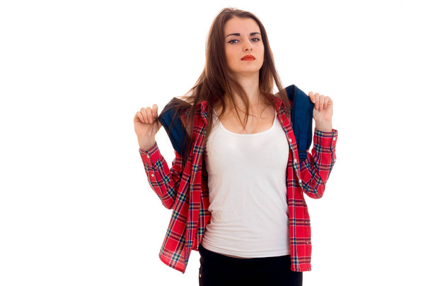 young tired brunette student girl with backpack on her shoulders posing and looking at the camera isolated on white background - Φωτογραφία, εικόνα