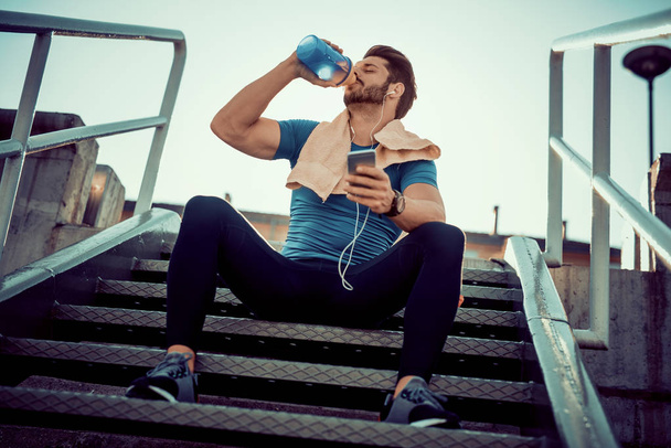 durstiger Sportler trinkt nach dem Training Wasser - Foto, Bild