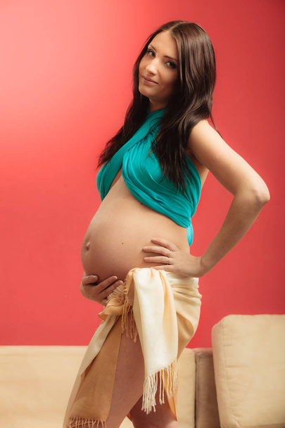 Attractive pregnant woman touching her belly - Foto, Imagen