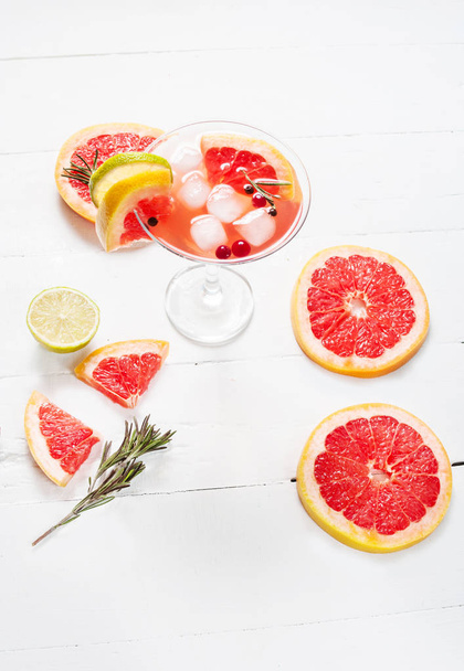 Refreshing homemade grapefruit and rosemary cocktail on white wooden table - Photo, Image