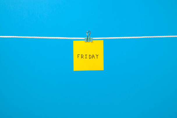 Yellow paper note on clothesline with text Friday - Фото, изображение