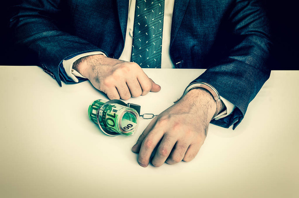 Man in suit chained with handcuffs to money - retro style - Fotó, kép