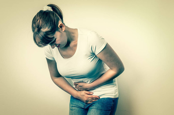 Femme avec des douleurs menstruelles tient son ventre douloureux
 - Photo, image