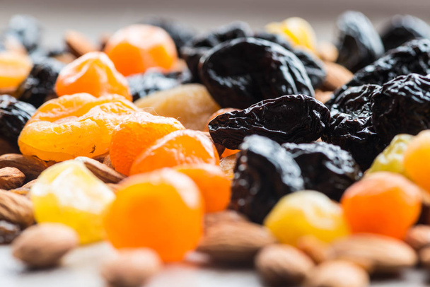 sušené švestky, sušené meruňky, sušené mandarinky a mandle na lehké dřevěné pozadí - Fotografie, Obrázek