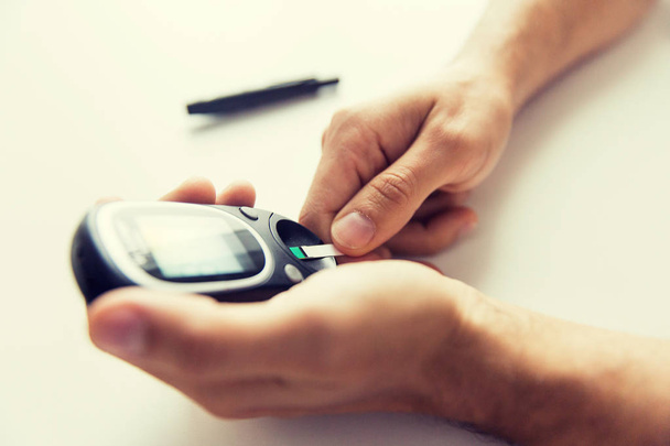 close up of man checking blood sugar by glucometer - Foto, immagini