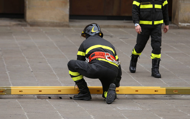 vigili del fuoco durante le operazioni di soccorso con una scala in legno
 - Foto, immagini