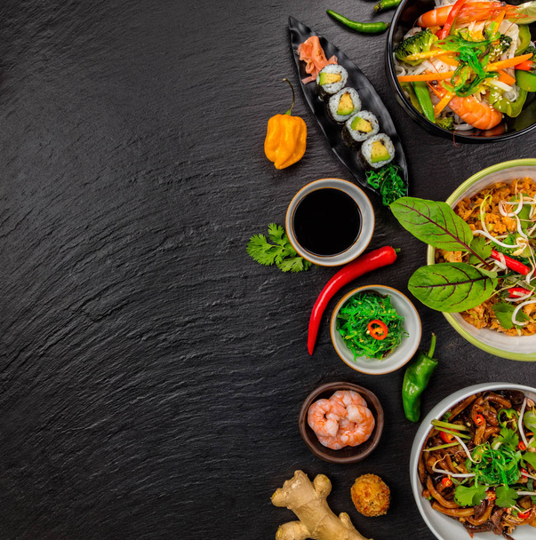 Asian food served on black stone, top view, space for text - Foto, Imagem