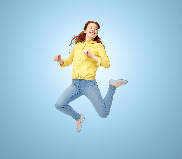 Χαμογελαστή νεαρή γυναίκα που πηδάει στον αέρα - Φωτογραφία, εικόνα