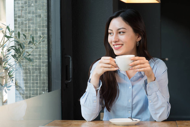 Donna attraente che beve caffè guardando fuori dalla finestra
 - Foto, immagini