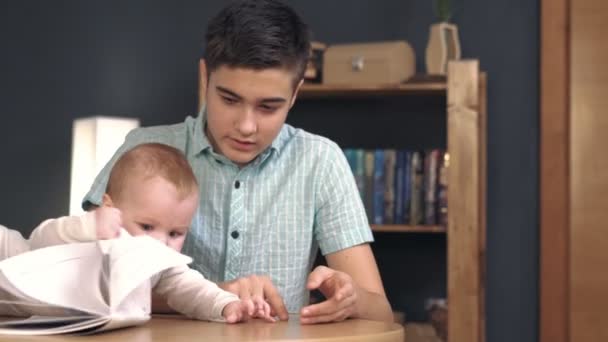 Teenager shows pictures newborn baby - Séquence, vidéo