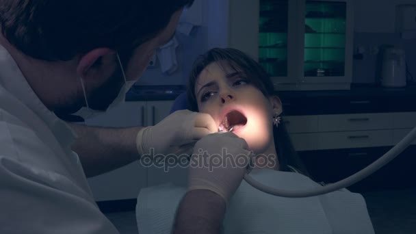 Dentist during treatment examines teeth girl private clinic patient. - Video