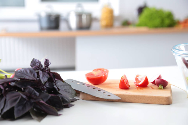 Fresh vegetables on the cutting board, salad in a glass dish. Concept of cooking - Photo, Image