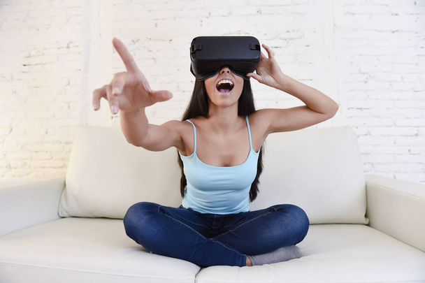 onnellinen nainen kotona olohuone sohva sohva innoissaan käyttäen 3D suojalasit katsomassa 360 virtuaalitodellisuus
 - Valokuva, kuva