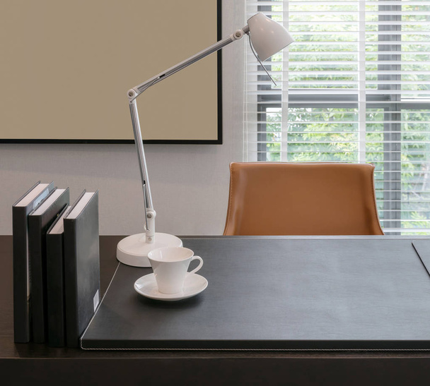 wooden table with lamp and books in modern working room interior - Zdjęcie, obraz