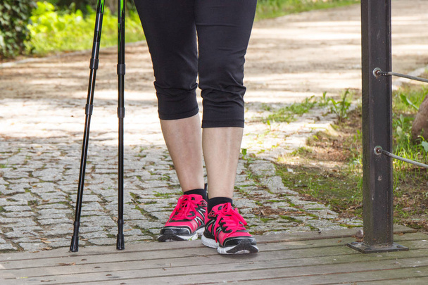 Legs of elderly senior woman and nordic walking sticks, sporty lifestyles - Valokuva, kuva