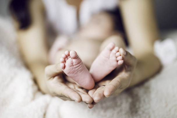 Baby voeten in moeder handen - Foto, afbeelding