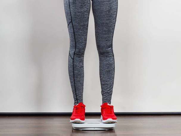 Woman wearing sportswear standing on weight machine - Φωτογραφία, εικόνα