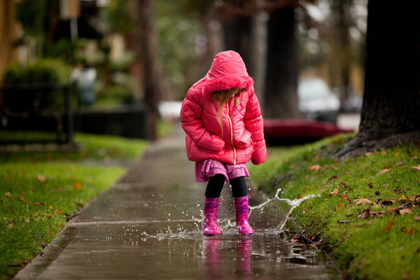 Молодая девушка играет в столь необходимый калифорнийский дождь
. - Фото, изображение