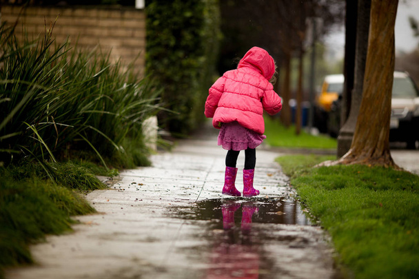 A young girl is playing in the much needed California rain. - Photo, Image
