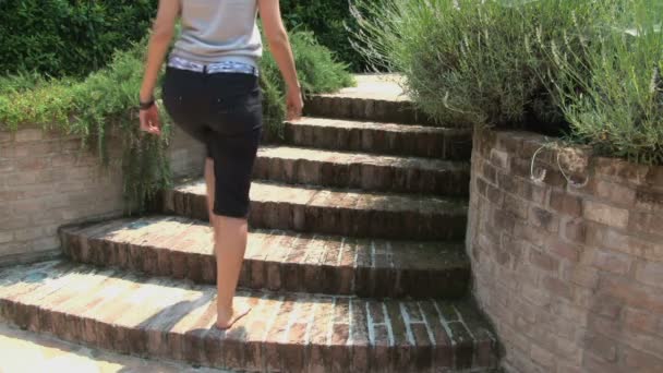 裸足の女性が庭で階段を下って行く - 映像、動画
