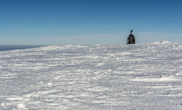 Mochila com machados de gelo e postes de trekking na neve
. - Foto, Imagem