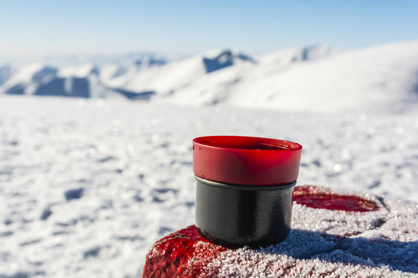 Chá quente em uma xícara de uma garrafa térmica na mesa com um mar limite
 - Foto, Imagem