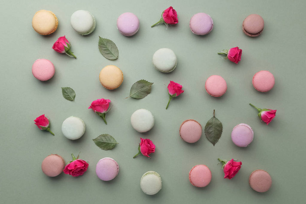 Macarons flat lay withroses and leaves on green background. Top view - Foto, immagini