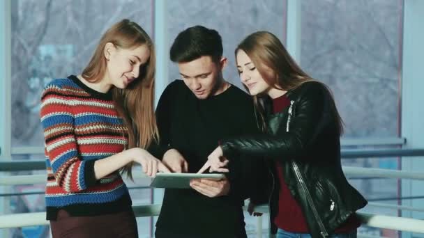 Het gezelschap van vrolijke jonge mensen een touch scherm tablet gadget gebruiken . - Video