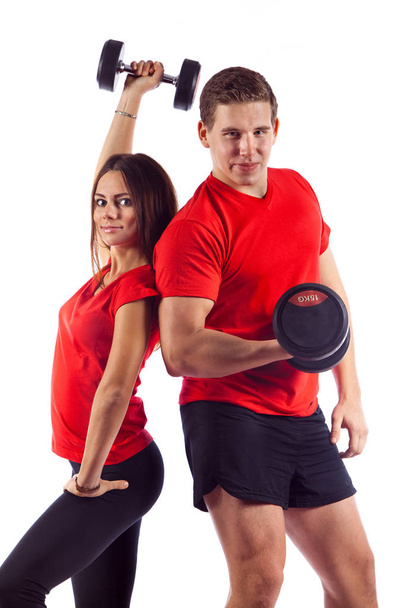 muskulöser Bodybuilder Kerl mit Frau macht Übungen mit Kurzhanteln vor weißem Hintergrund - Foto, Bild