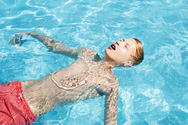 Підліток відпочиває в басейні
 - Фото, зображення