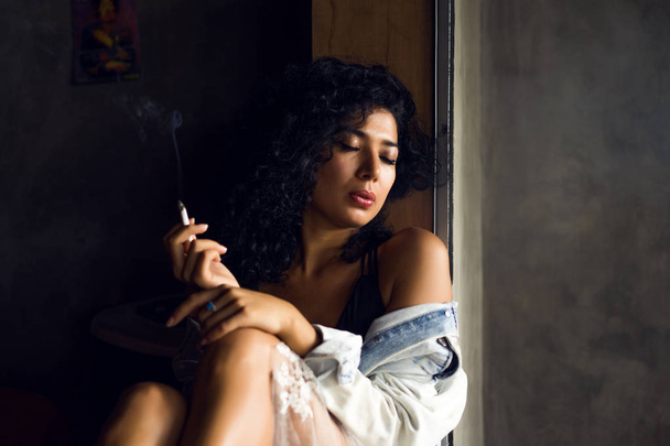 Young woman smoking - 写真・画像