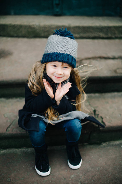 Little cute girl sitting on stairs - Фото, изображение
