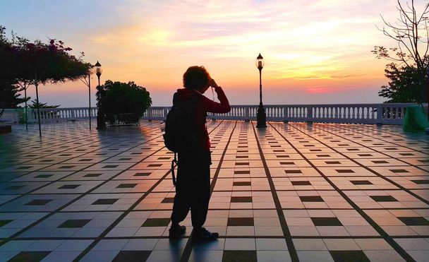 Σιλουέτα της γυναίκας που στέκεται να τραβήξετε τη φωτογραφία του δραματική sunrise - Φωτογραφία, εικόνα