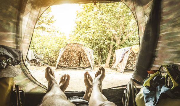 キャンプ テント - 旅行放浪癖概念冒険体験を楽しんでいる若者 - 内側の足のカップルの視点ぼやけたエッジを足とレトロな緑フィルターにソフト フォーカス - 写真・画像