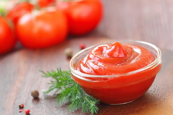 Томатний соус кетчуп з приправами у скляній мисці
 - Фото, зображення