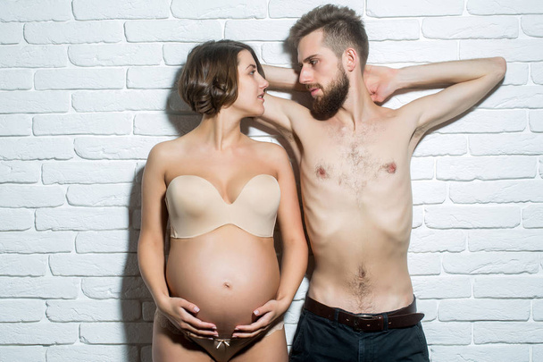 bearded slim man and pretty pregnant woman with round belly - Foto, Imagem