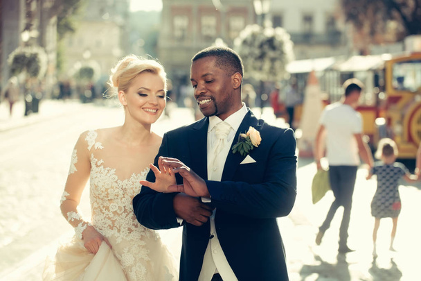 Happy african American groom and cute bride walking on street - Foto, immagini