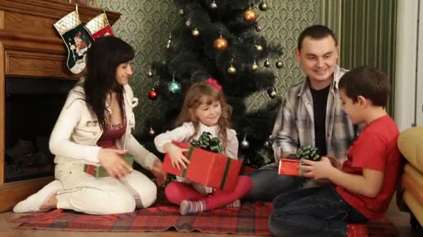 Eine Familie hat sich in der Nähe eines Weihnachtsbaums versammelt. Geschenke zu Weihnachten. - Filmmaterial, Video