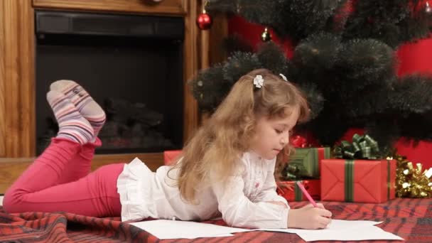 ein Mädchen unter einem Weihnachtsbaum wartet darauf, ihre Geschenke auszupacken. Warten auf Weihnachten. - Filmmaterial, Video