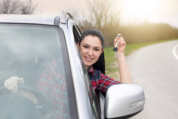 Nő, autó vezetés, és mutatja a kulcsok - Fotó, kép