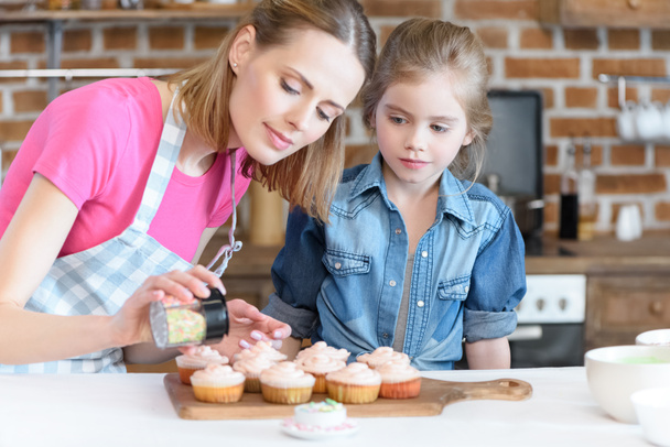mother and daughter baking cupcakes - Photo, Image