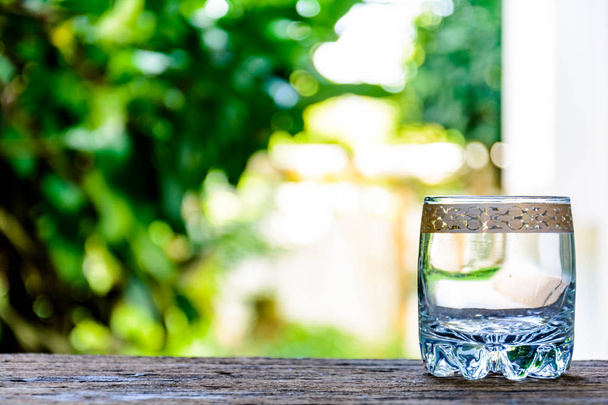 glas water op oude houten tafel - Foto, afbeelding