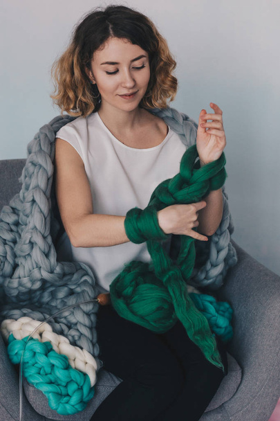 Young woman knittig merino wool - Foto, afbeelding