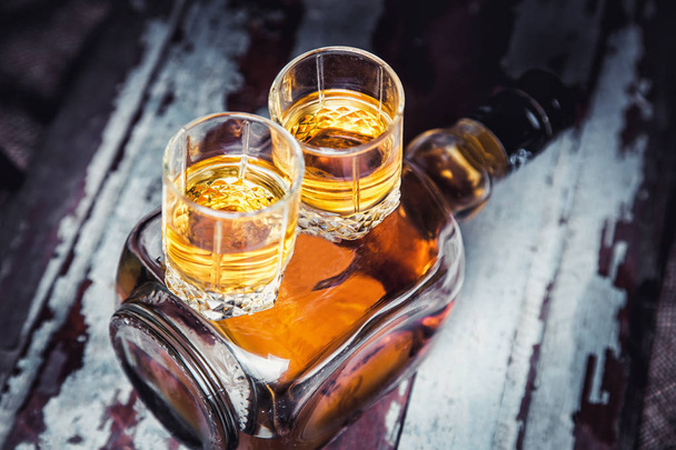 whiskey bottle and glass on a wooden vintage background - Fotó, kép