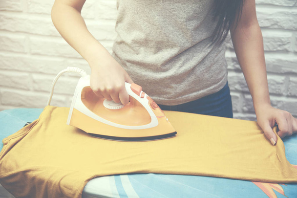 woman ironing T-shirt - Fotoğraf, Görsel