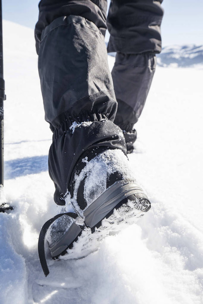 Зимові трекінгові чоботи на сніговій доріжці
 - Фото, зображення