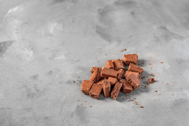 Milk  chocolate is on the gray background - Foto, Imagen